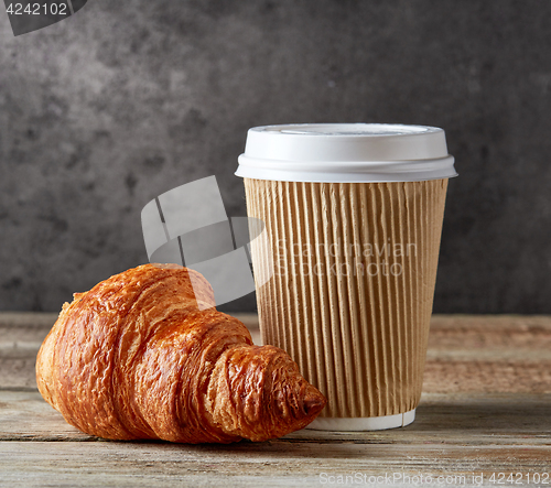 Image of paper coffee cup and croissant