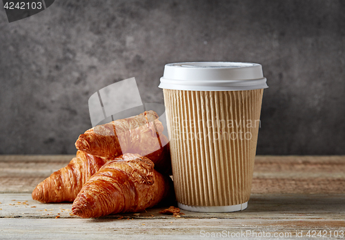 Image of paper coffee cup and croissants