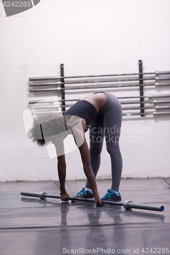 Image of black woman lifting empty bar