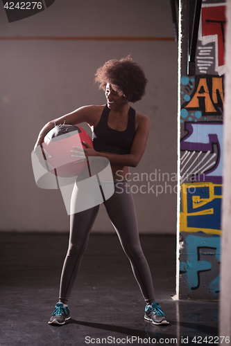 Image of black woman carrying crossfit ball