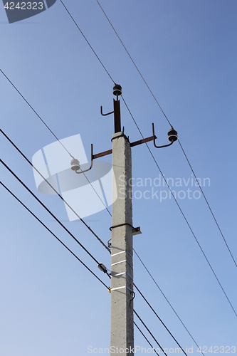 Image of Concrete electric pole with wires against the sky