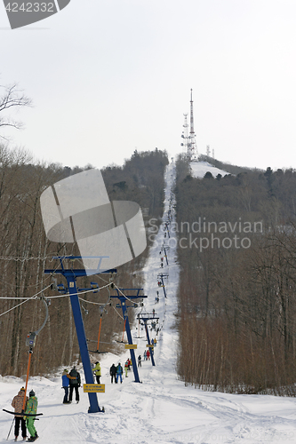 Image of Snowboarder using a surface lift on the slope.