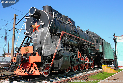 Image of Old black locomotive in the railway depot in the parking lot
