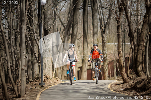 Image of Two cyclists drive around park