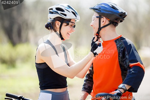 Image of Two athletes wear bicycle helmets