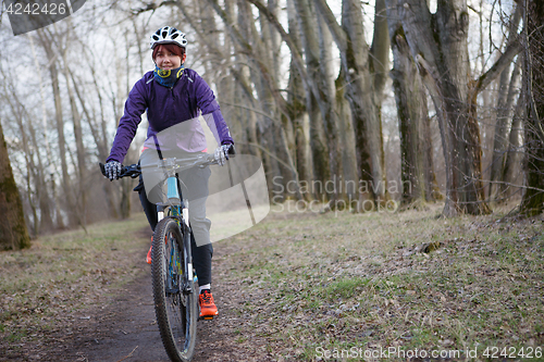 Image of Girl in helmet riding bicycle
