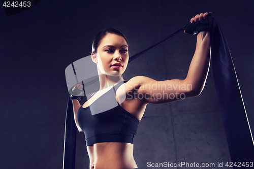 Image of woman with expander exercising in gym