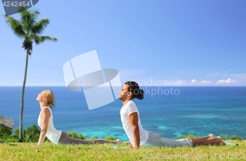 Image of couple making yoga cobra pose outdoors