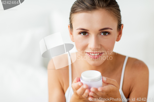 Image of close up of happy woman holding cream jar