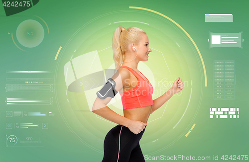 Image of sporty woman running with smartphone and earphones