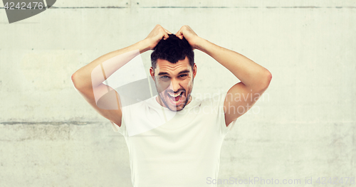 Image of crazy shouting man in t-shirt over gray background