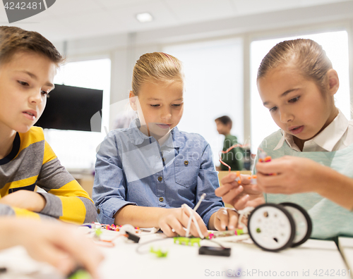 Image of happy children building robots at robotics school