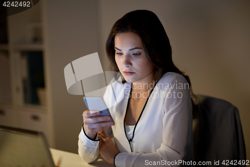 Image of businesswoman with smartphone at office