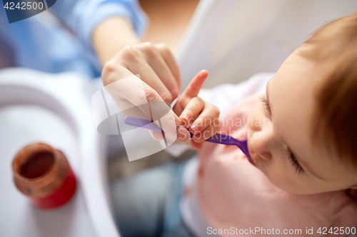 Image of close up of mother feeding baby with puree at home