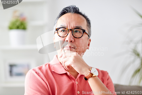 Image of asian man thinking at home