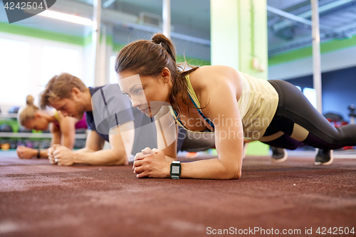 Image of woman with heart-rate tracker exercising in gym