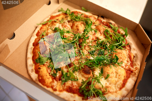 Image of close up of pizza in box on table at pizzeria
