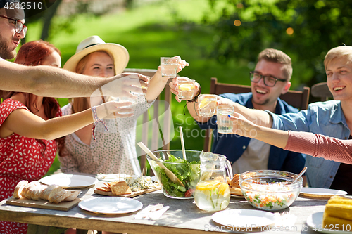 Image of happy friends with drinks at summer garden party