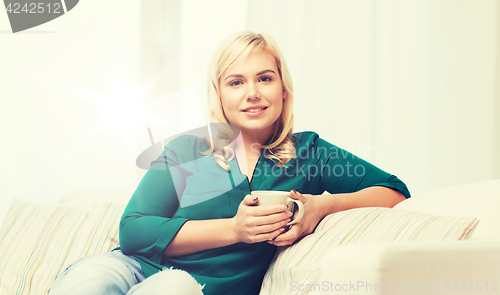 Image of happy woman  with cup of tea or coffee at home