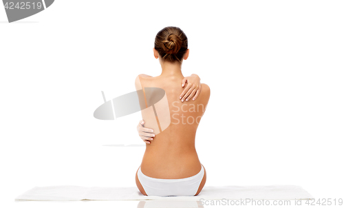 Image of beautiful topless young woman on towel from back