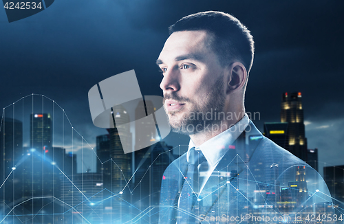 Image of businessman over night city and diagram charts