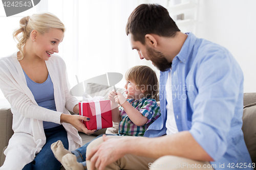 Image of happy family with birthday gift at home