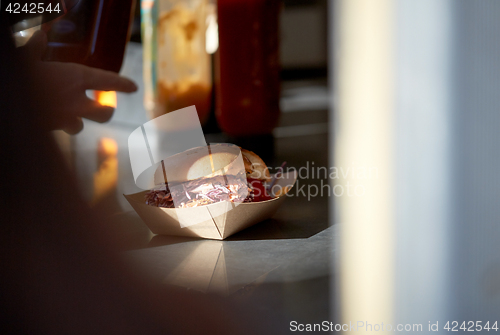 Image of hamburger in disposable paper plate on table