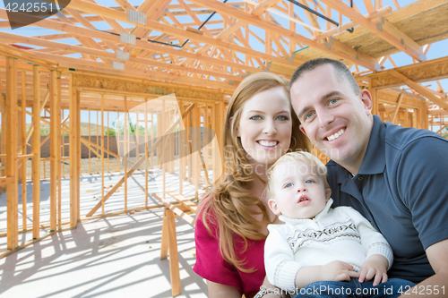 Image of Young Military Family Inside The Framing of Their New Home at Co