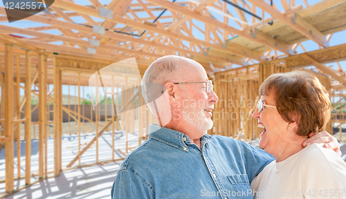 Image of Senior Couple On Site Inside Their New Home Construction Framing