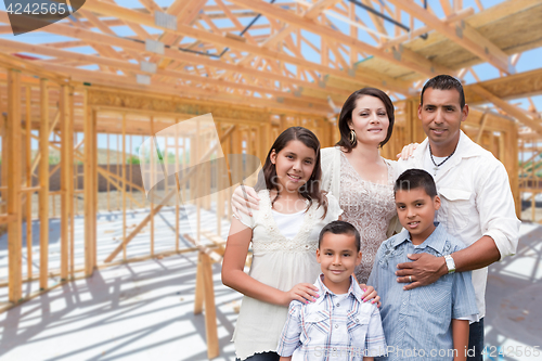 Image of Young Hispanic Family On Site Inside New Home Construction Frami