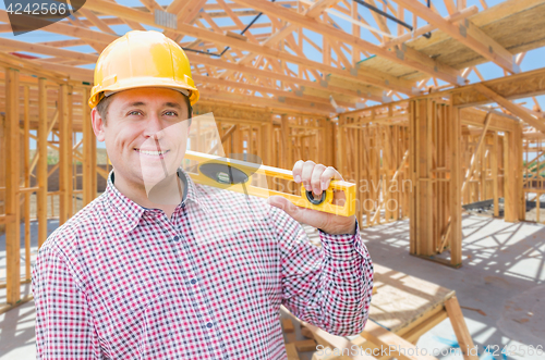 Image of Contractor With Level On Site Inside New Home Construction Frami