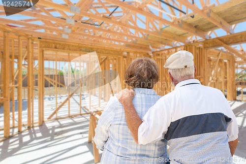 Image of Senior Couple On Site Inside Their New Home Construction Framing