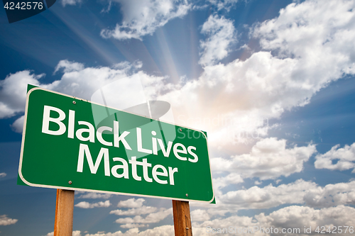 Image of Black Lives Matter Green Road Sign with Dramatic Clouds and Sky