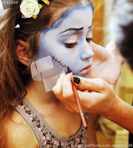 Image of little cute child making facepaint on birthday party, zombie Apo