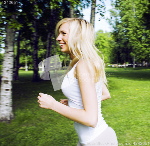 Image of blonde real girl doing yoga in green park, lifestyle sport peopl