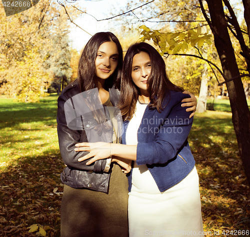 Image of mature real mother with daughter outside autumn fall in park