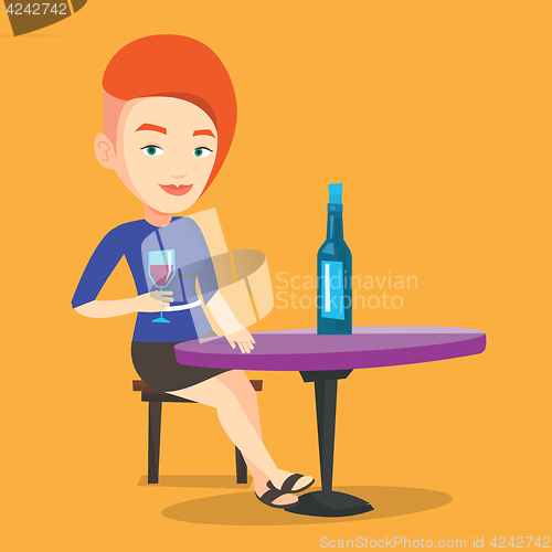 Image of Woman drinking wine at restaurant.