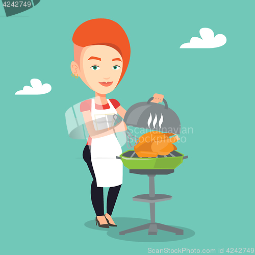 Image of Woman cooking chicken on barbecue grill.