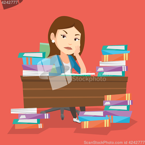 Image of Student sitting at the table with piles of books.