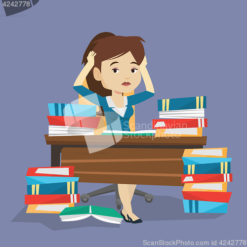 Image of Student sitting at the table with piles of books.