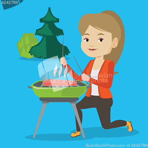 Image of Woman cooking steak on barbecue grill.