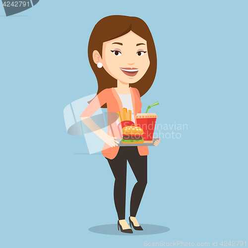 Image of Woman holding tray full of fast food.