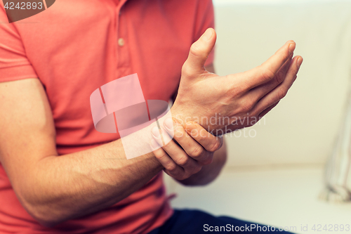 Image of close up of man with  pain in hand at home