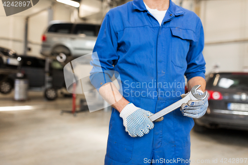 Image of auto mechanic or smith with wrench at car workshop