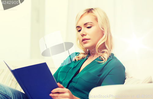 Image of woman reading book at home