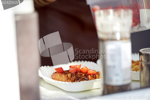 Image of waffle with strawberry on paper plate and fork