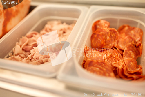 Image of containers with ham and salami at restaurant