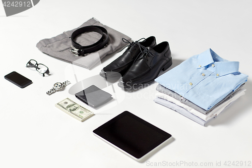 Image of clothes, gadgets and business stuff on table