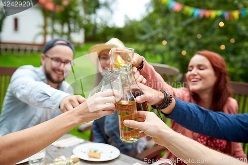 Image of happy friends with drinks at summer garden party