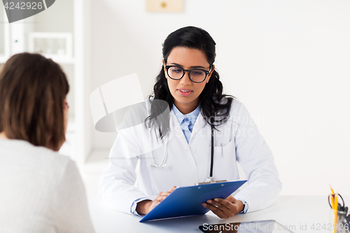 Image of doctor with clipboard and woman at hospital